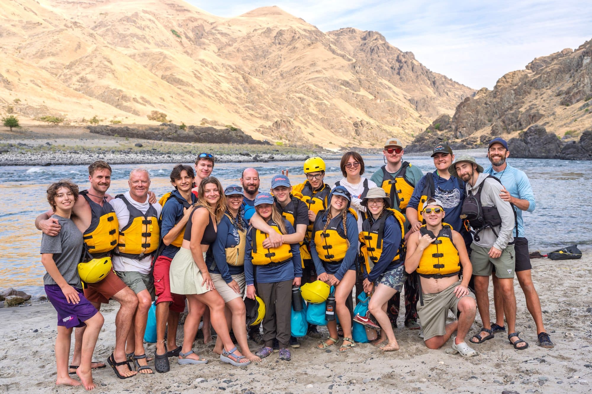 A group wearing life jackets beside a river