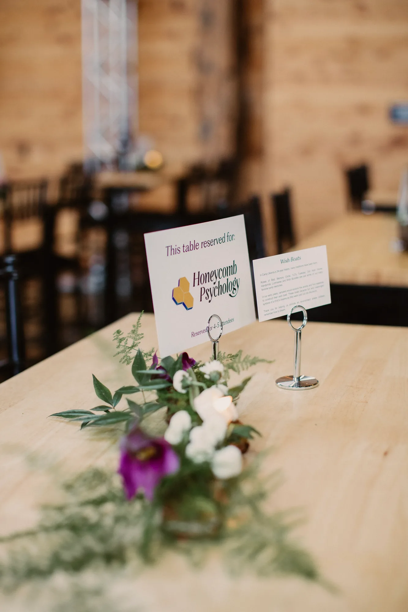 A sponsor's table card and centrepiece in the barn at Wine & Dine for Hope & Joy