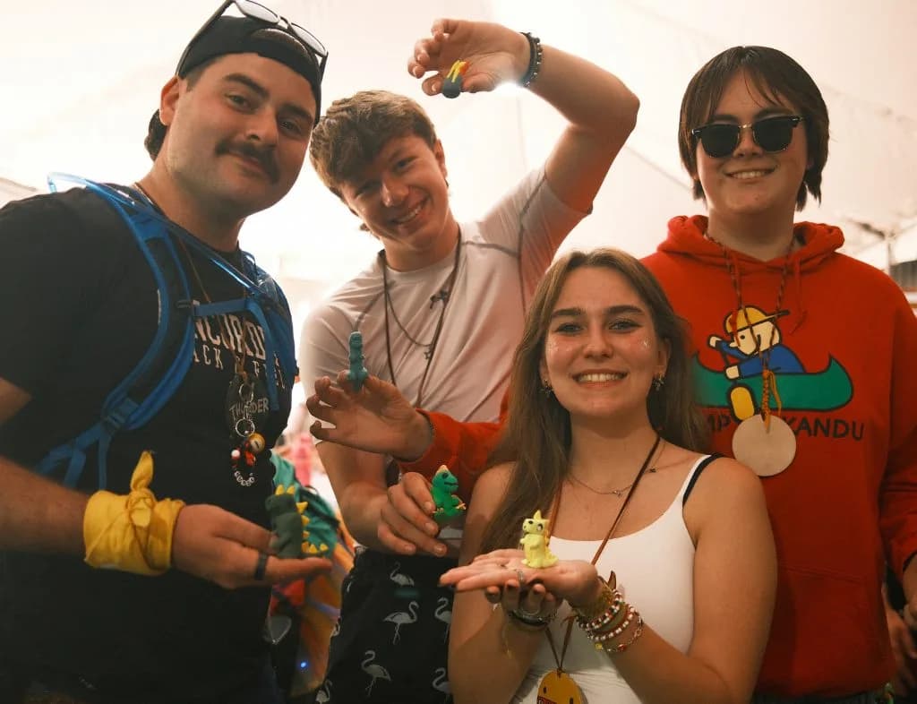 Volunteer and campers holding up art